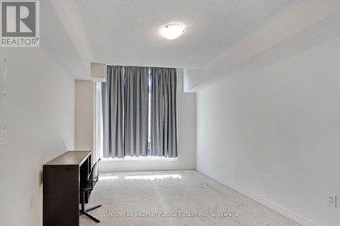 A room with a desk and a window with curtains.