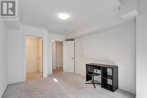 A white bedroom with a desk and a chair.