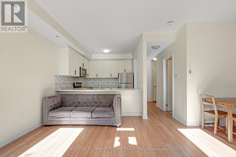 A living room with a grey couch and a wooden table.