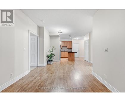 A spacious room with wooden flooring and white walls.