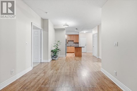 A spacious room with wooden flooring and white walls.