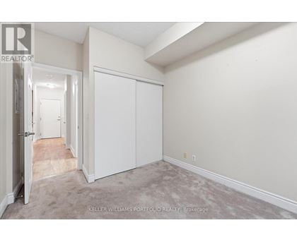 A realtor photo of a white bedroom with a carpeted floor.