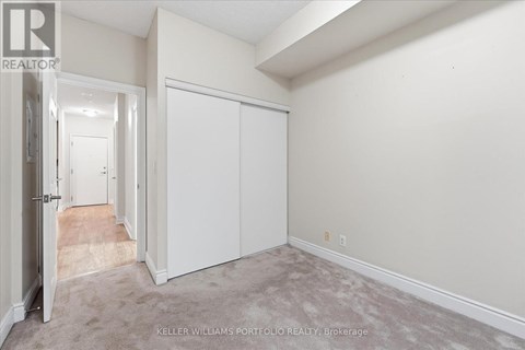 A realtor photo of a white bedroom with a carpeted floor.