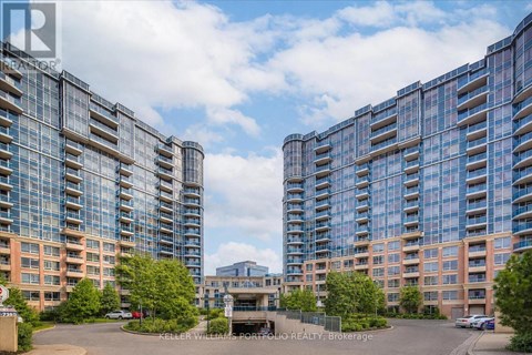 A large, modern building complex with a central courtyard and a cloudy sky above.