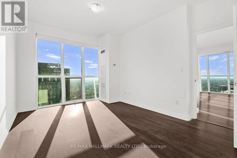 A spacious room with a large window overlooking a cityscape.
