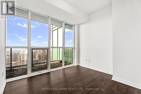 A room with a view of the city through large windows.
