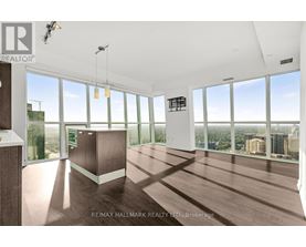 A spacious room with large windows overlooking a cityscape.