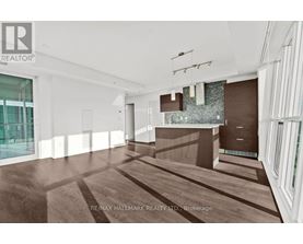 A modern, empty room with wood flooring and white walls.