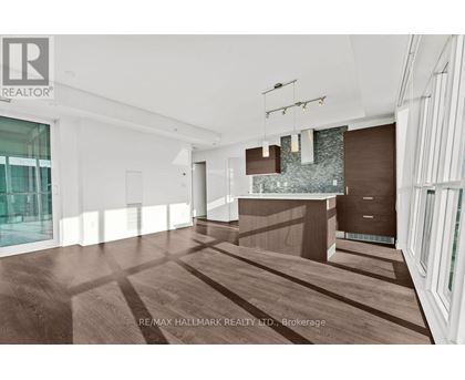 A modern, empty room with wood flooring and white walls.