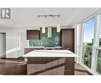 A modern kitchen with a large island and a view of the city.