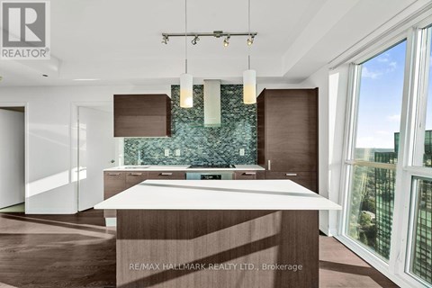 A modern kitchen with a large island and a view of the city.