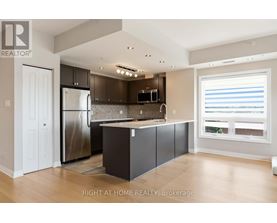 A modern kitchen with a refrigerator, microwave, and cabinets.