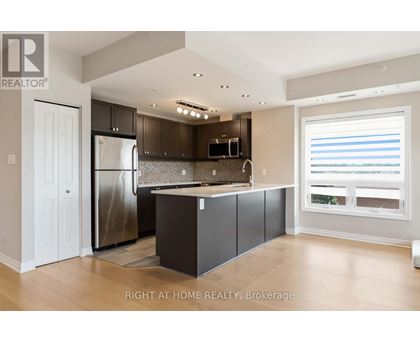 A modern kitchen with a refrigerator, microwave, and cabinets.