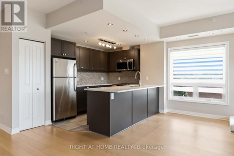 A modern kitchen with a refrigerator, microwave, and cabinets.
