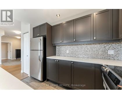 A kitchen with a refrigerator, cabinets and a counter top.