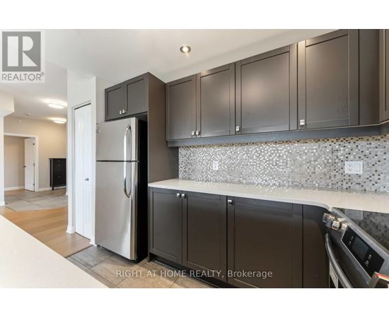 A kitchen with a refrigerator, cabinets and a counter top.
