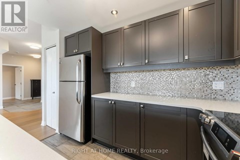 A kitchen with a refrigerator, cabinets and a counter top.