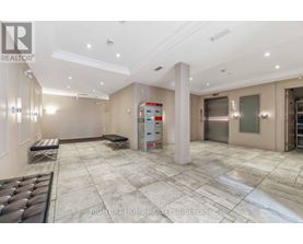 A spacious, well-lit room with a marble floor and a large white pillar in the center.
