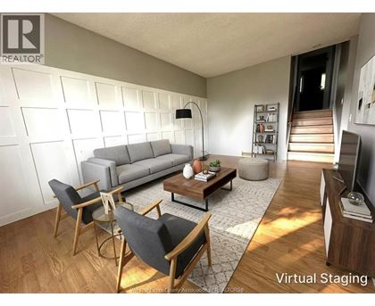 A living room with a grey couch, a coffee table, and a television.