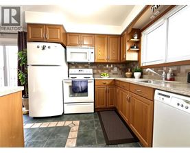 A kitchen with wooden cabinets and a white refrigerator.