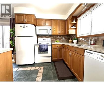 A kitchen with wooden cabinets and a white refrigerator.