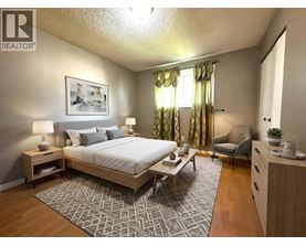 A bedroom with a large bed, a chair, and a painting on the wall.