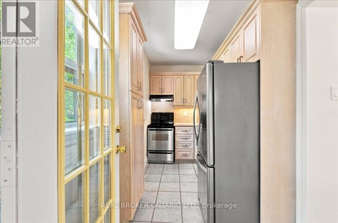 A kitchen with a refrigerator, oven, and cabinets.
