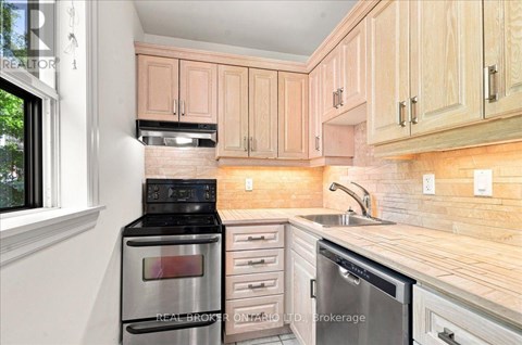 A kitchen with wooden cabinets and stainless steel appliances.