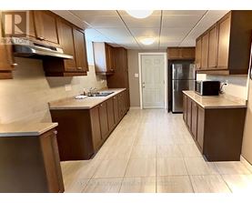 A kitchen with brown cabinets and a white door.