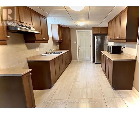 A kitchen with brown cabinets and a white door.