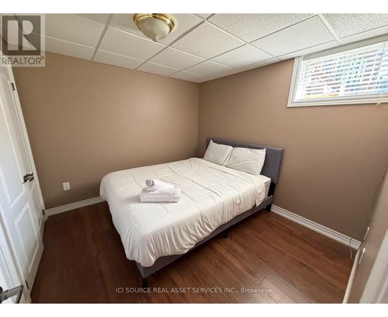 A bedroom with a bed, pillows, and a towel on the bed.