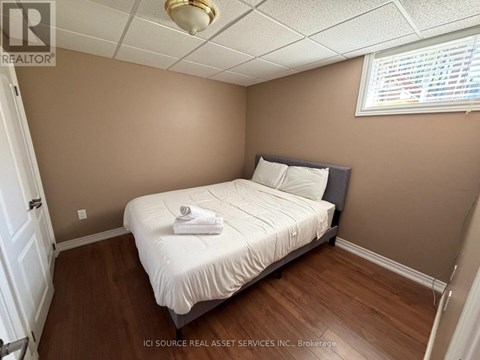 A bedroom with a bed, pillows, and a towel on the bed.