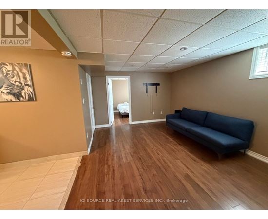 A living room with a blue couch and a wooden floor.