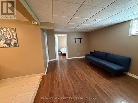 A living room with a blue couch and a wooden floor.