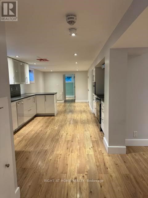 A well-lit kitchen with wooden floors and modern appliances.