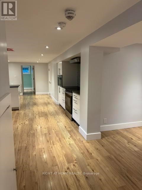 A long hallway with wood floors and white walls.
