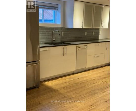 A kitchen with white cabinets and a wooden floor.