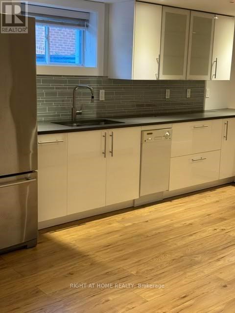 A kitchen with white cabinets and a wooden floor.