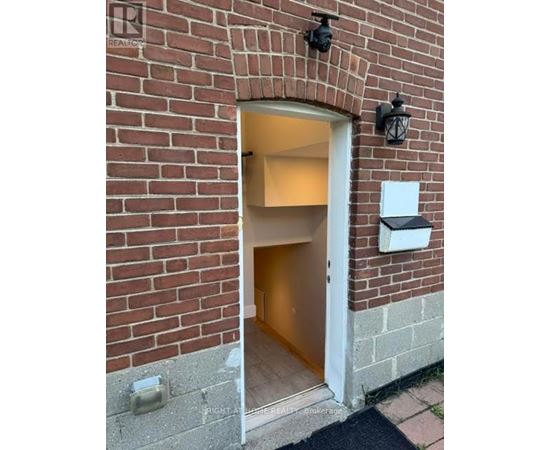 A doorway in a brick wall with a Realty sign above it.