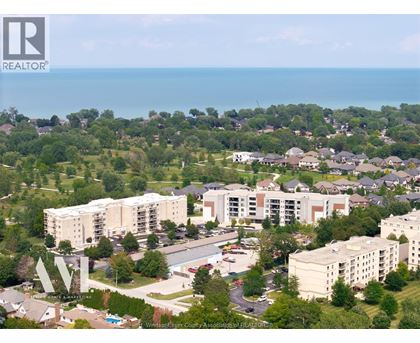 A bird's eye view of a residential area with apartment buildings and a swimming pool.