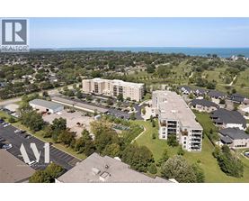 A bird's eye view of a residential area with apartment buildings and a parking lot.