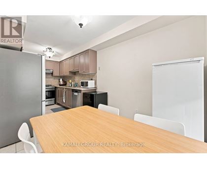 A kitchen with a table and chairs in front of it.