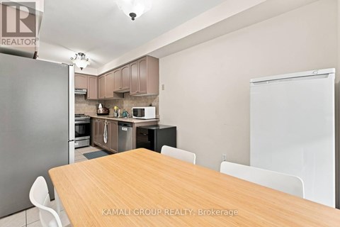 A kitchen with a table and chairs in front of it.