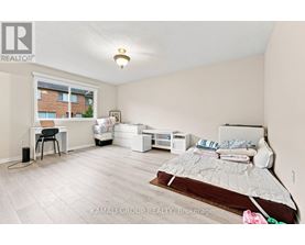 A bedroom with a bed, desk, and chair.