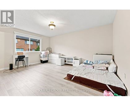 A bedroom with a bed, desk, and chair.