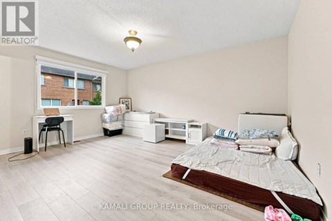 A bedroom with a bed, desk, and chair.