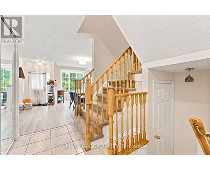 A spacious living room with a staircase leading to the upper floor.