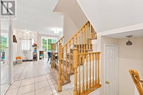 A spacious living room with a staircase leading to the upper floor.