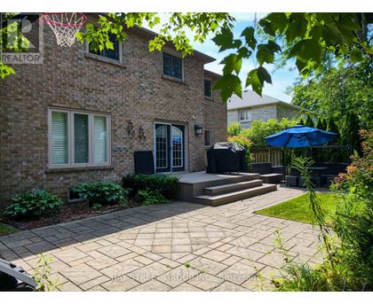 A brick house with a patio and a basketball hoop.