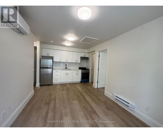 A kitchen with white cabinets and a wooden floor.